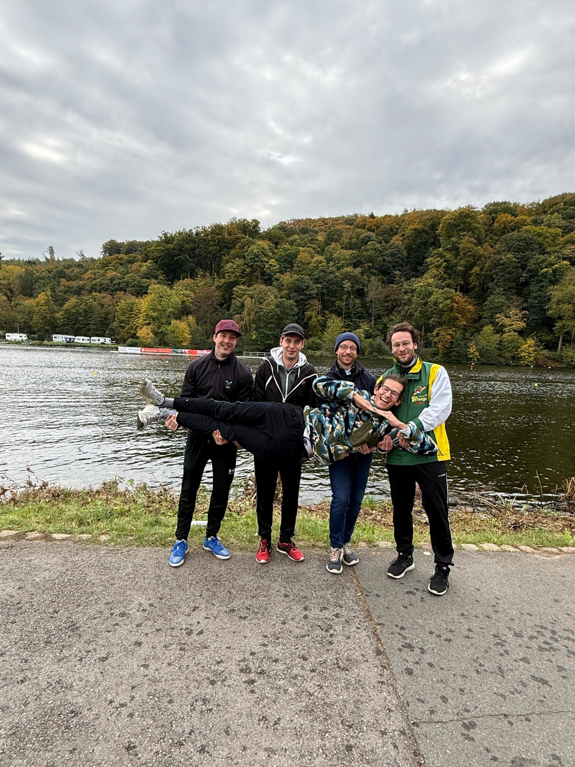 Mannschaftsfoto und eine Person wird von den anderen quer gehalten